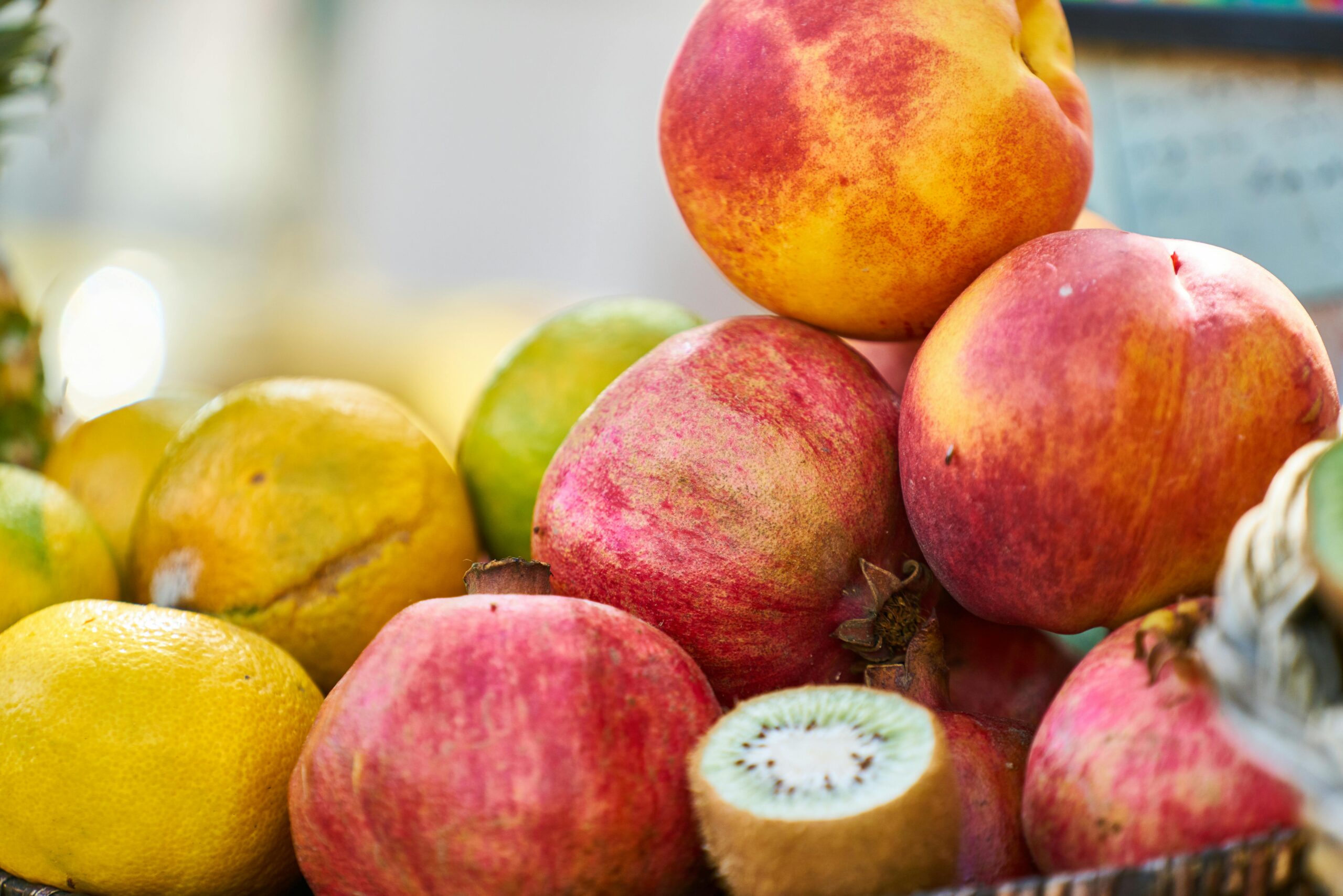 Vibrant assortment of fresh fruits including citrus, kiwi, and pomegranate, showcasing healthy, colorful produce.